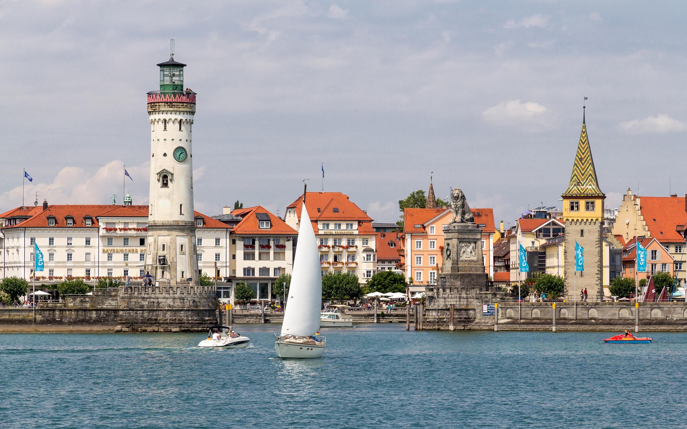 Il porto di Lindau sul lago di Costanza con il faro, il leone e una barca a vela